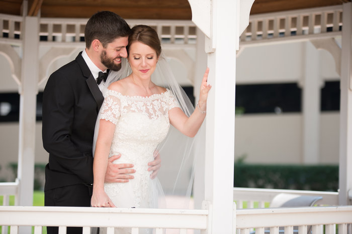 Amy and Tom smiling together on a white-railed veranda.